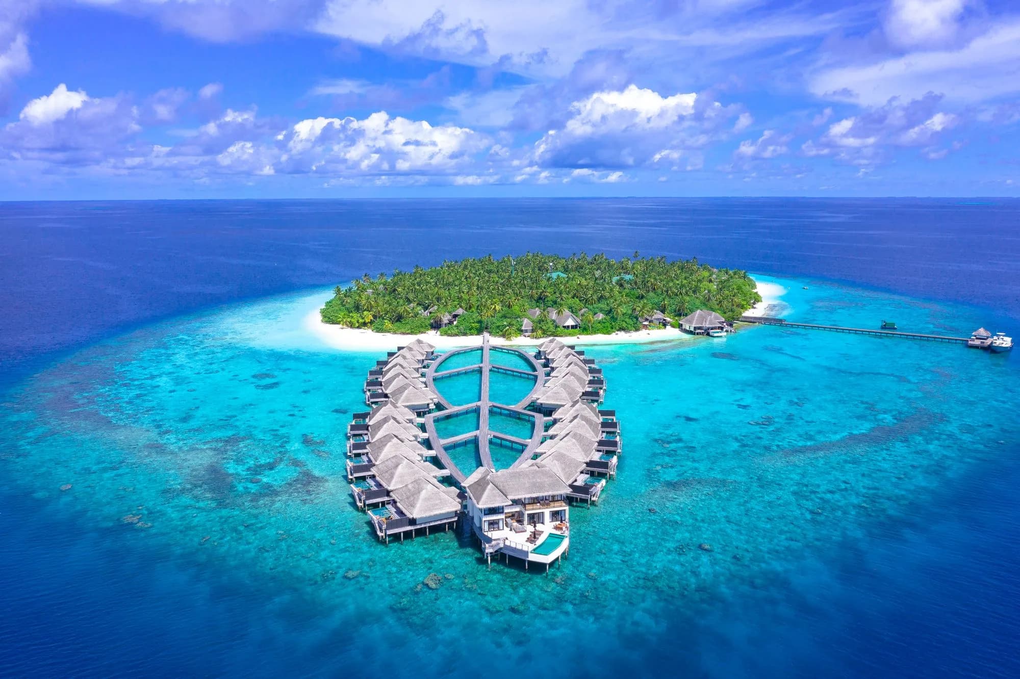 A private island resort ringed by overwater villas and reef in the Maldives