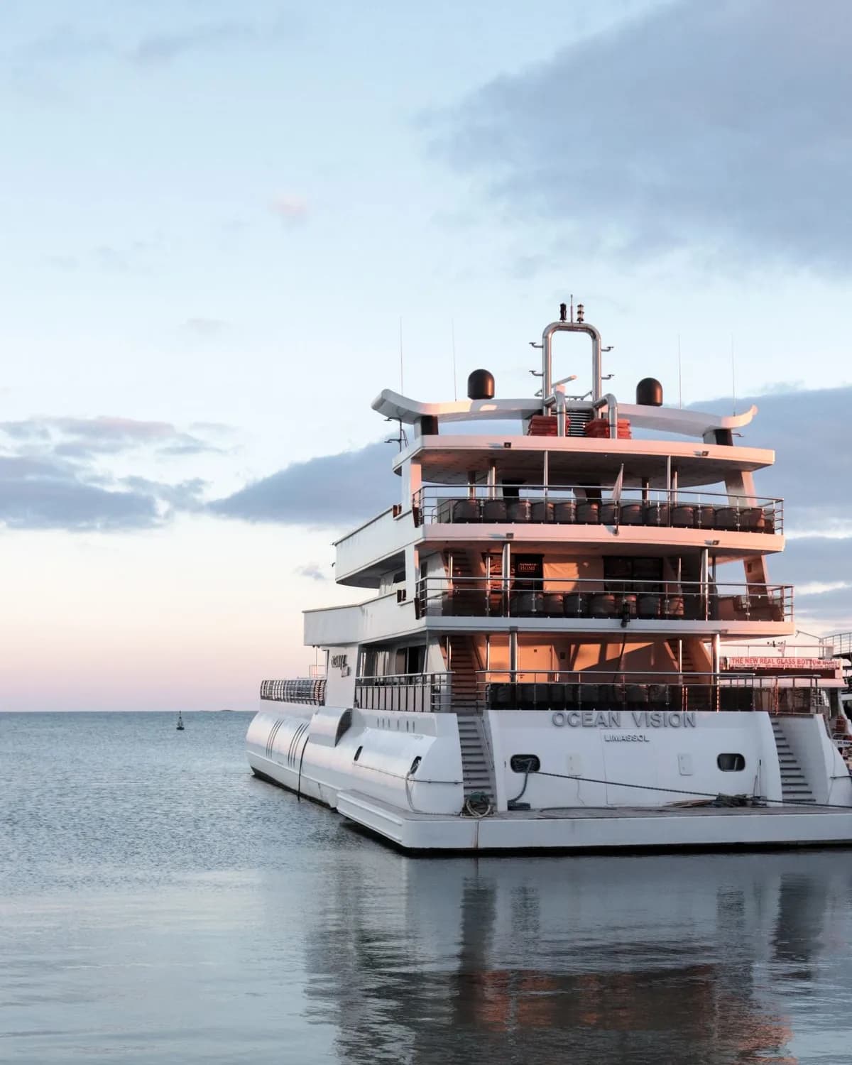 A motor yacht moored in a harbor at sunset
